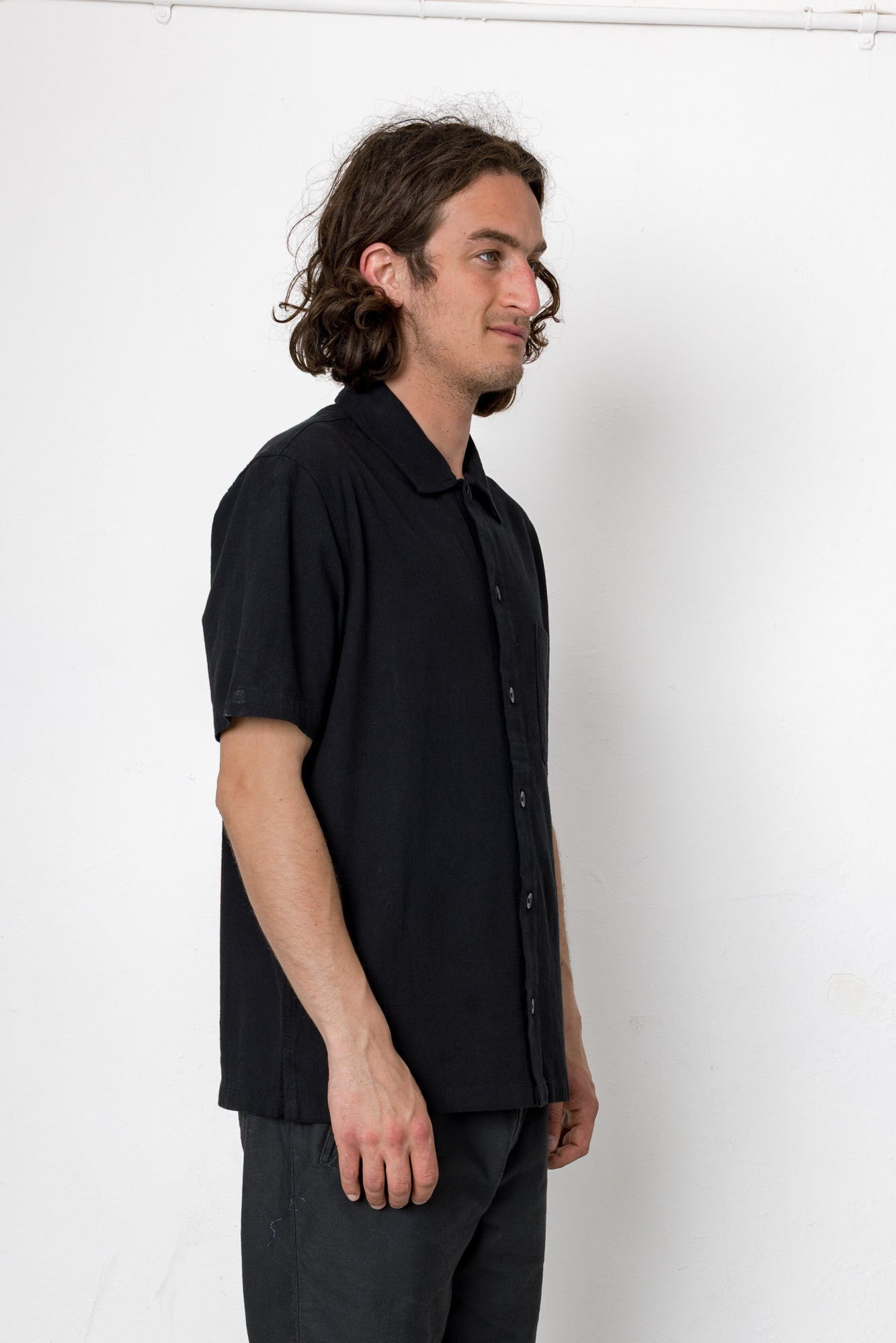 Man wearing a black short-sleeve shirt against a white background