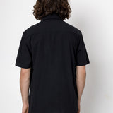 Person wearing a black shirt and pants against a white background