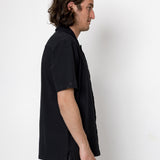 Man wearing a black shirt and pants against a white background