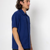 Man wearing a blue shirt against a white background