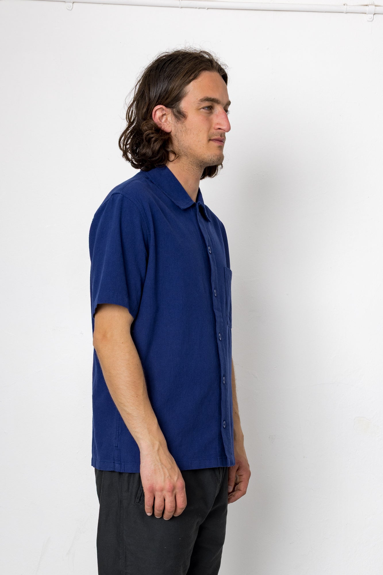 Man wearing a blue shirt against a white background