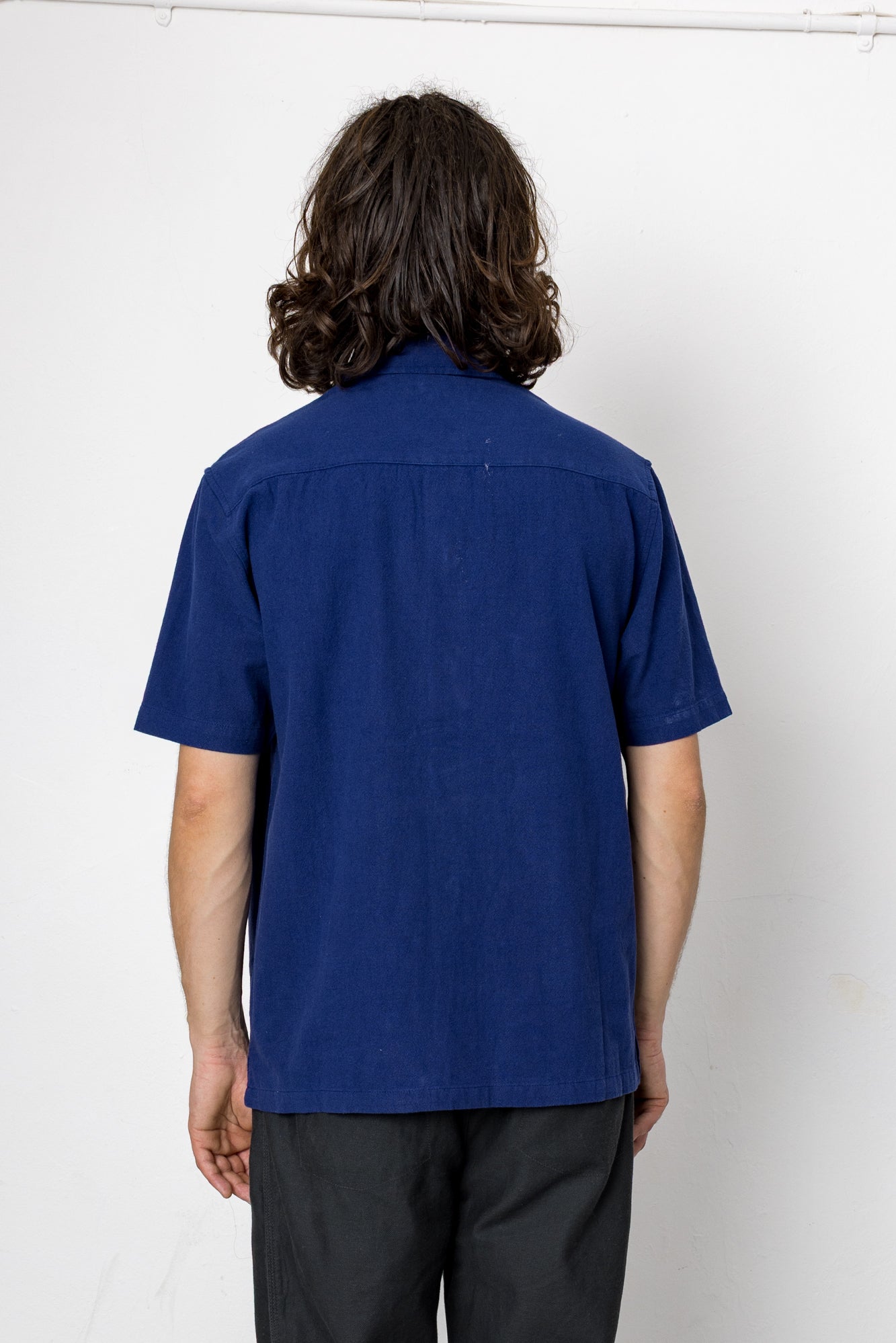 Person wearing a blue shirt against a white background