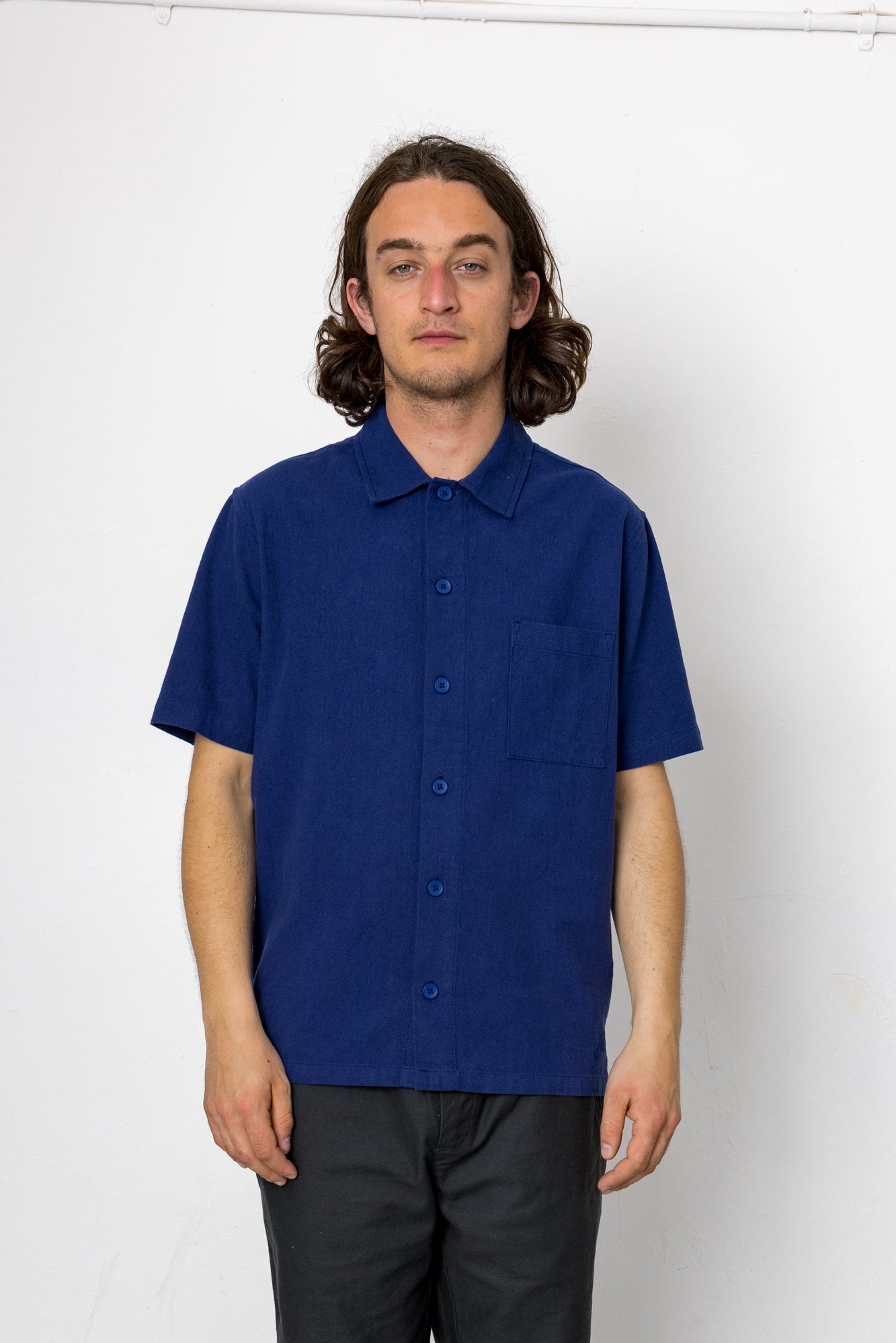 Person wearing a blue short-sleeve shirt against a white background