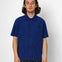 Person wearing a blue short-sleeve shirt against a white background