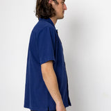Man wearing a blue shirt against a white background
