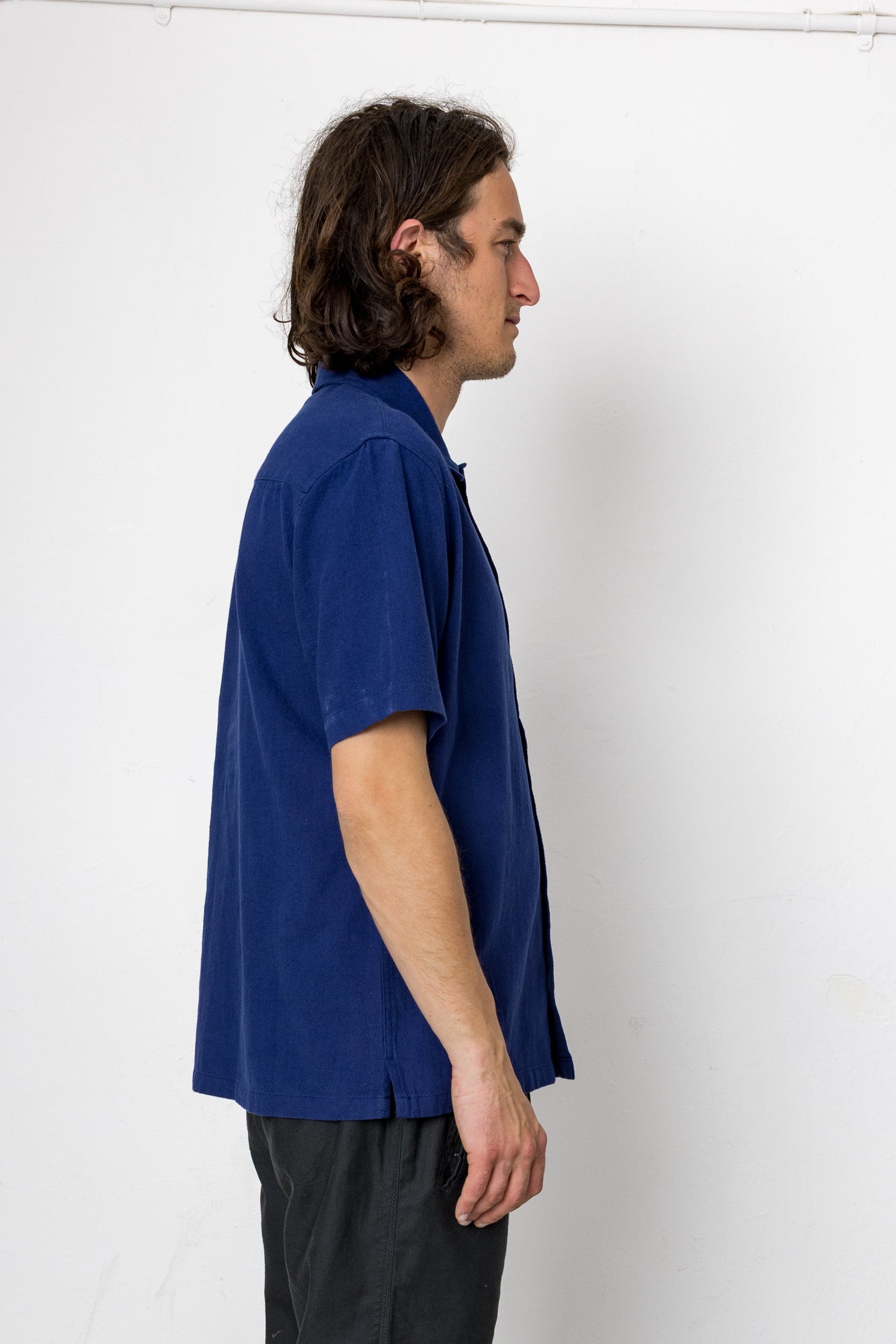 Man wearing a blue shirt against a white background