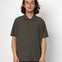 Man wearing a dark green short-sleeve shirt against a white background