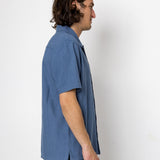 Man wearing a blue shirt against a white background