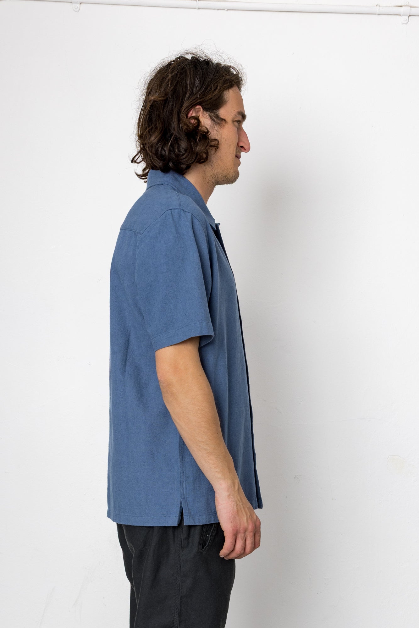 Man wearing a blue shirt against a white background
