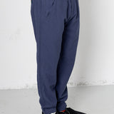 Person wearing blue pants and black shoes on a white background