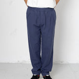 Person wearing blue pants and a white shirt against a plain background