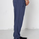Person wearing blue pants and black shoes on a white background