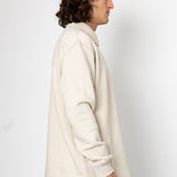 Person wearing a white coat against a plain background