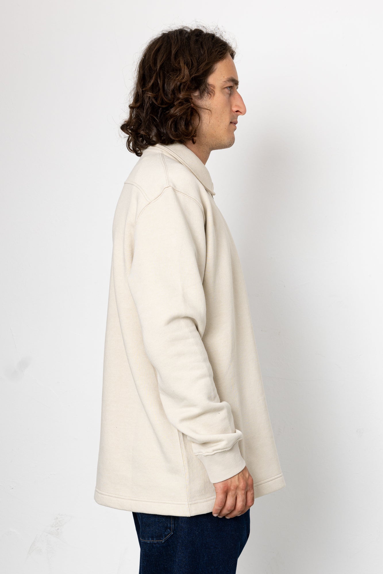 Person wearing a white coat against a plain background