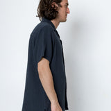 Man wearing a dark blue shirt against a white background