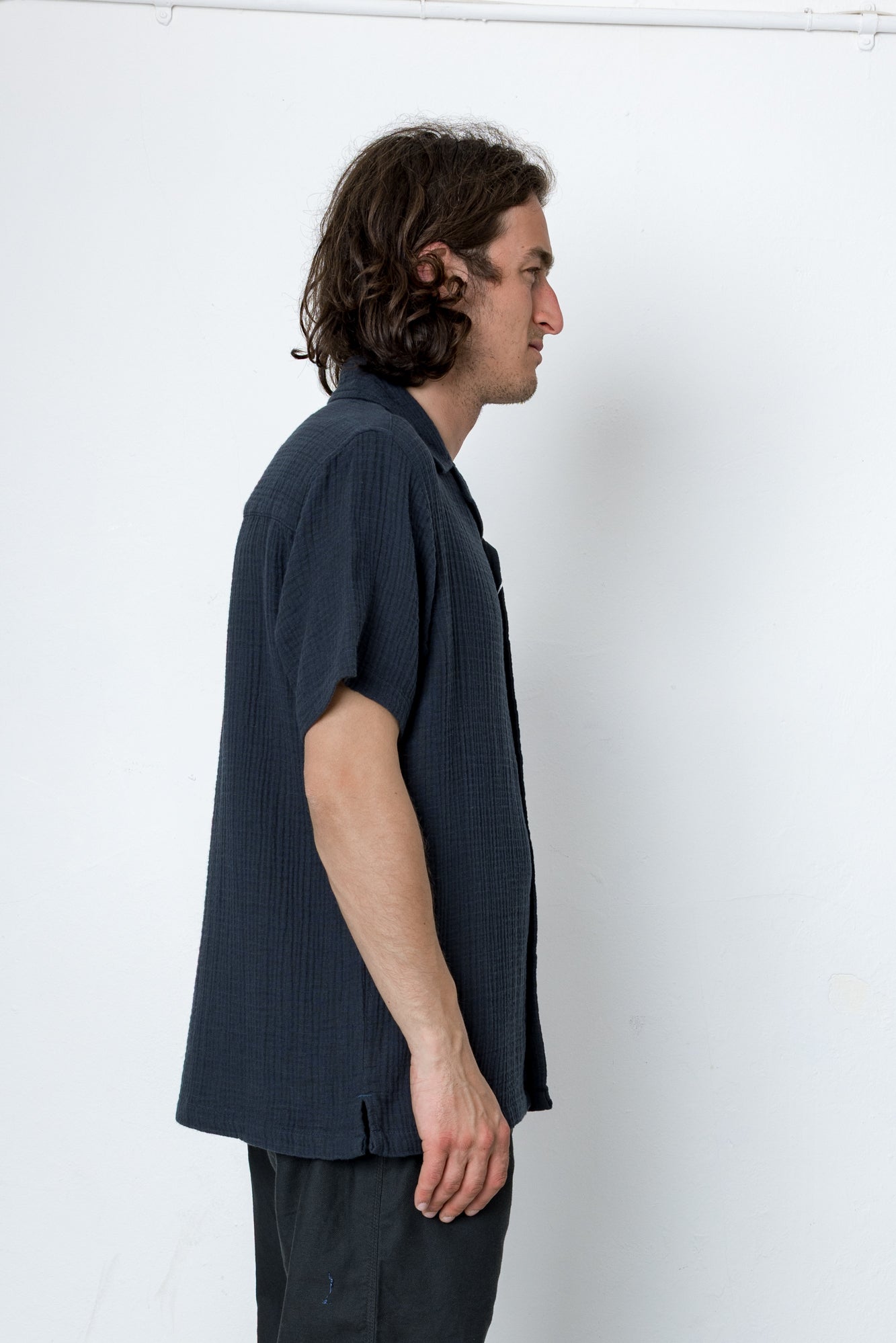 Man wearing a dark blue shirt against a white background