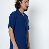 Man wearing a blue shirt against a white background