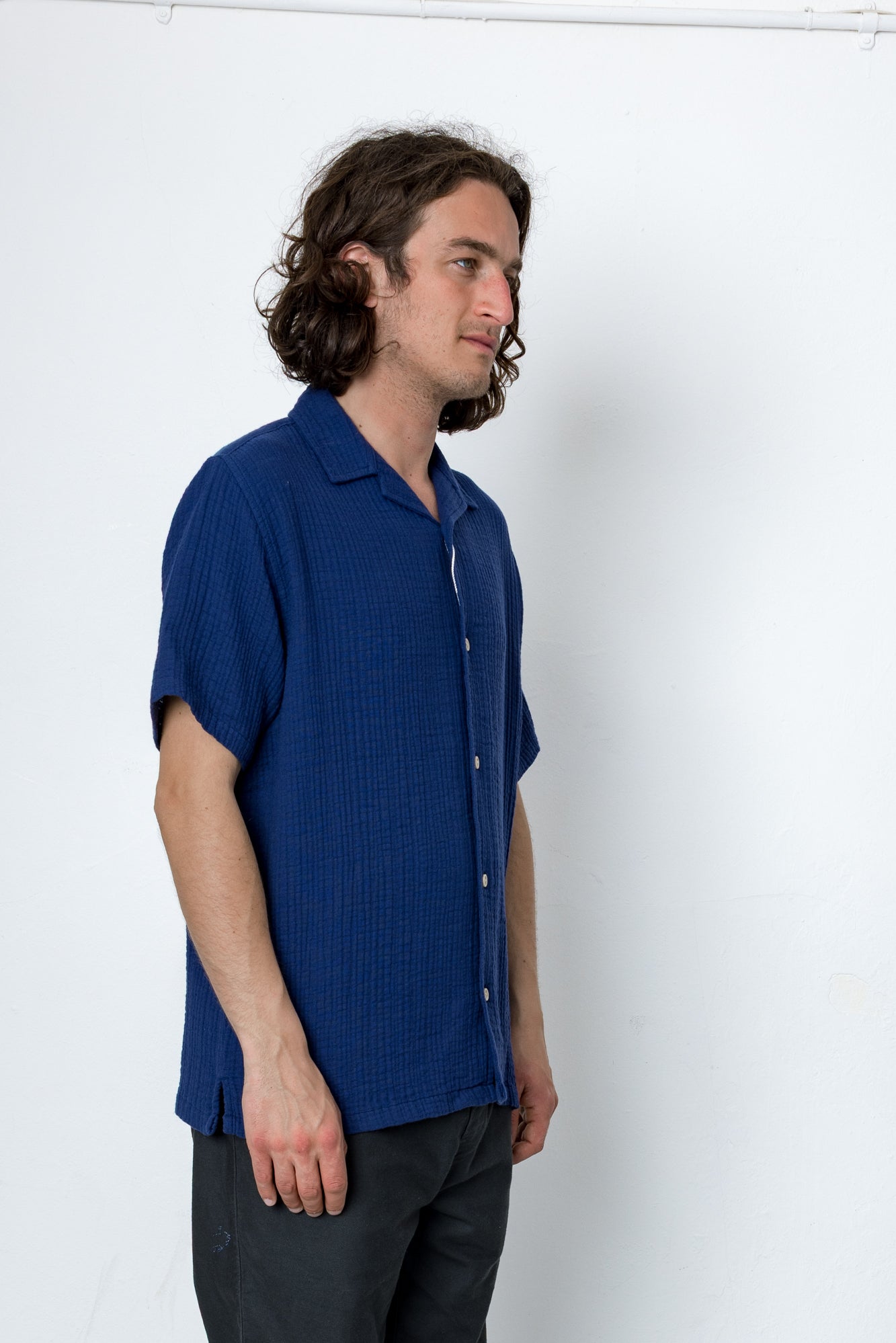 Man wearing a blue shirt against a white background