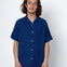 Man wearing a blue short-sleeve shirt against a white background