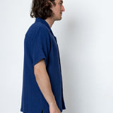 Man wearing a blue shirt against a white background