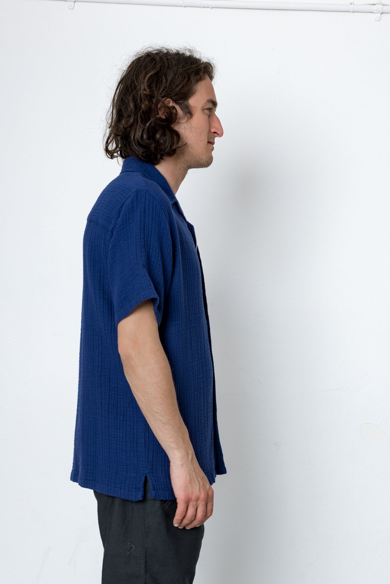 Man wearing a blue shirt against a white background