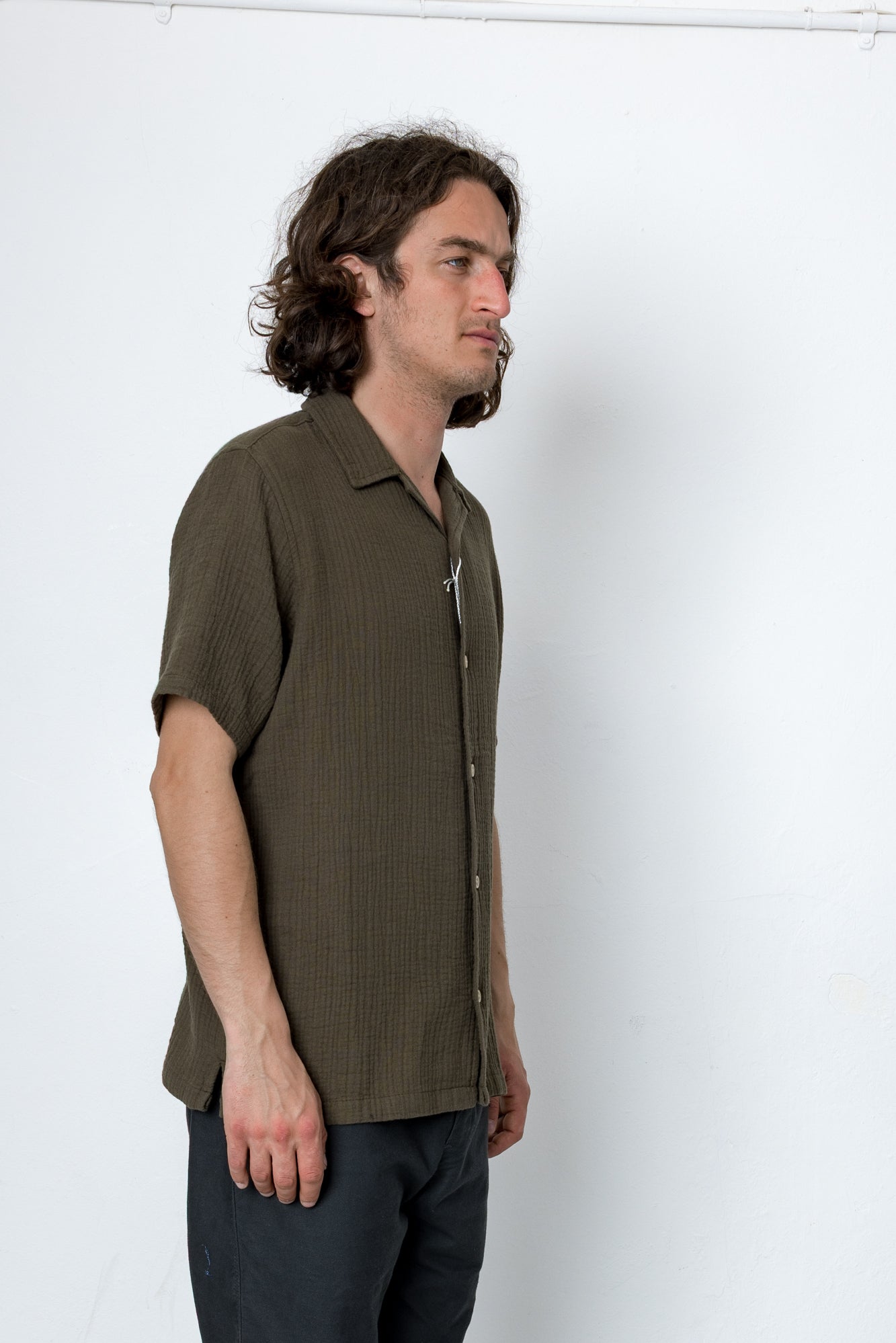 Man wearing a brown short-sleeve shirt against a white background