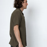 Man wearing a green shirt against a white background