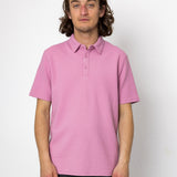 Person wearing a pink polo shirt against a white background