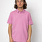 Person wearing a pink polo shirt against a white background