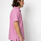 Person wearing a pink shirt against a white background