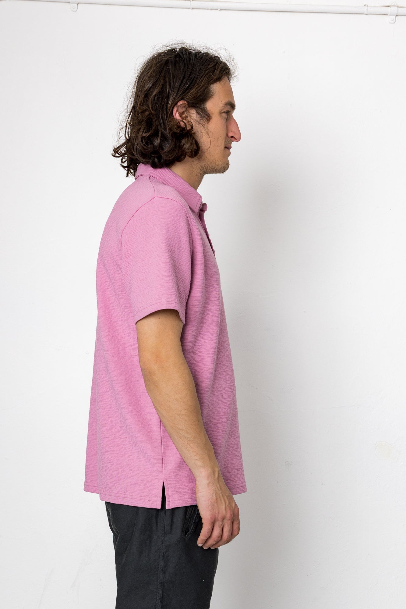 Person wearing a pink shirt against a white background