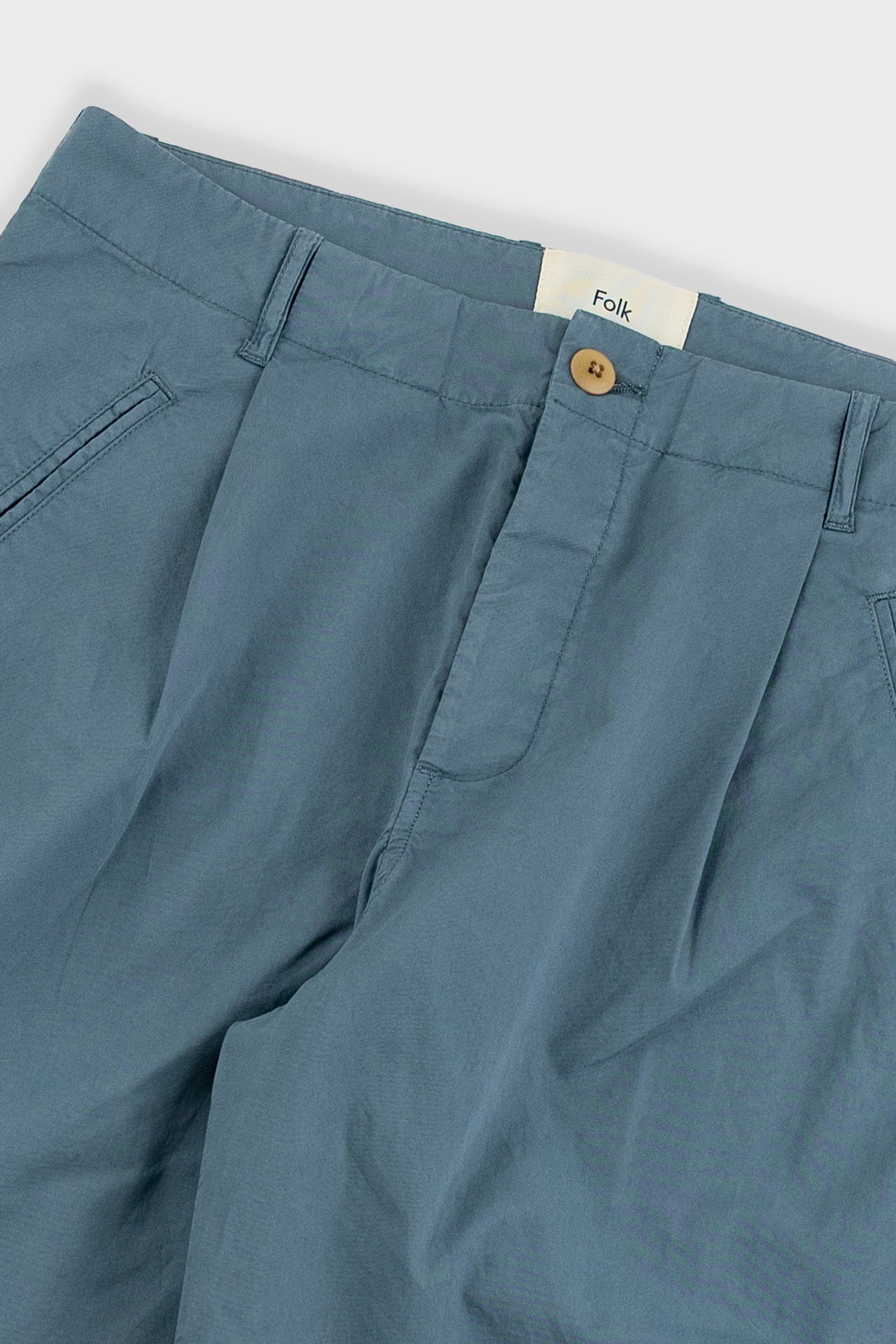 Blue pants with a visible brand label on a light gray background