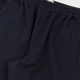 Close-up of dark navy blue trousers showing the elastic waistband and fabric texture.