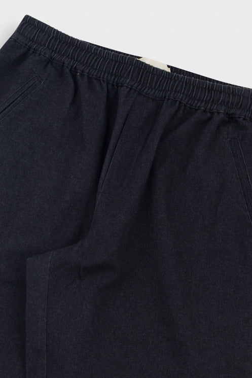 Close-up of dark navy blue trousers showing the elastic waistband and fabric texture.