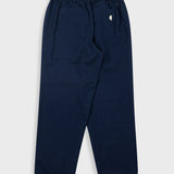 A pair of navy blue sweatpants with an elastic waistband and a small white embroidered logo on the left hip, shown flat against a light gray background.