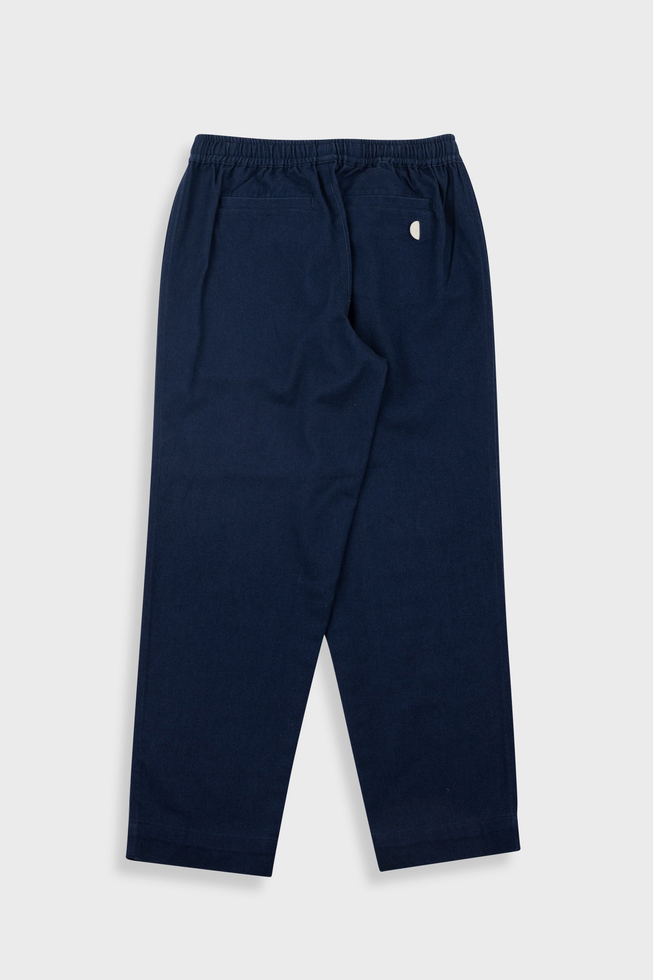 A pair of navy blue sweatpants with an elastic waistband and a small white embroidered logo on the left hip, shown flat against a light gray background.