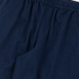 Close-up of dark navy blue pants showing the elastic waistband and side pocket seam.