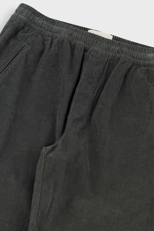 Dark gray pants with an elastic waistband on a light gray background