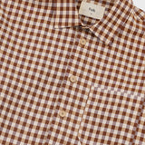 A close-up of a brown and beige gingham checkered button-down shirt by Folk, featuring a classic collar and light-colored buttons.