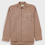 A long-sleeve button-up shirt with a brown and beige gingham check pattern, featuring a single chest pocket and a pointed collar, shown against a light gray background.