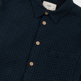 Navy checkered shirt with brown buttons on a white background