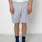 Person wearing blue and white striped shorts with a plain background