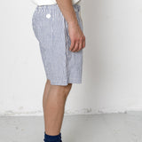 Person wearing blue and white striped shorts with a plain background