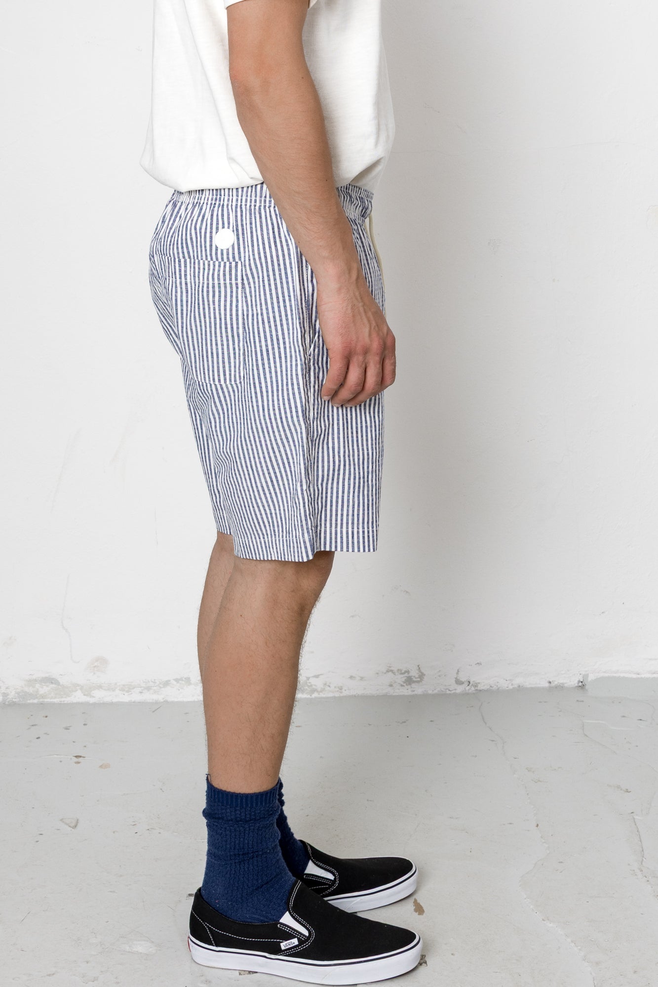 Person wearing blue and white striped shorts with a plain background