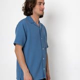 Man wearing a blue shirt against a white background