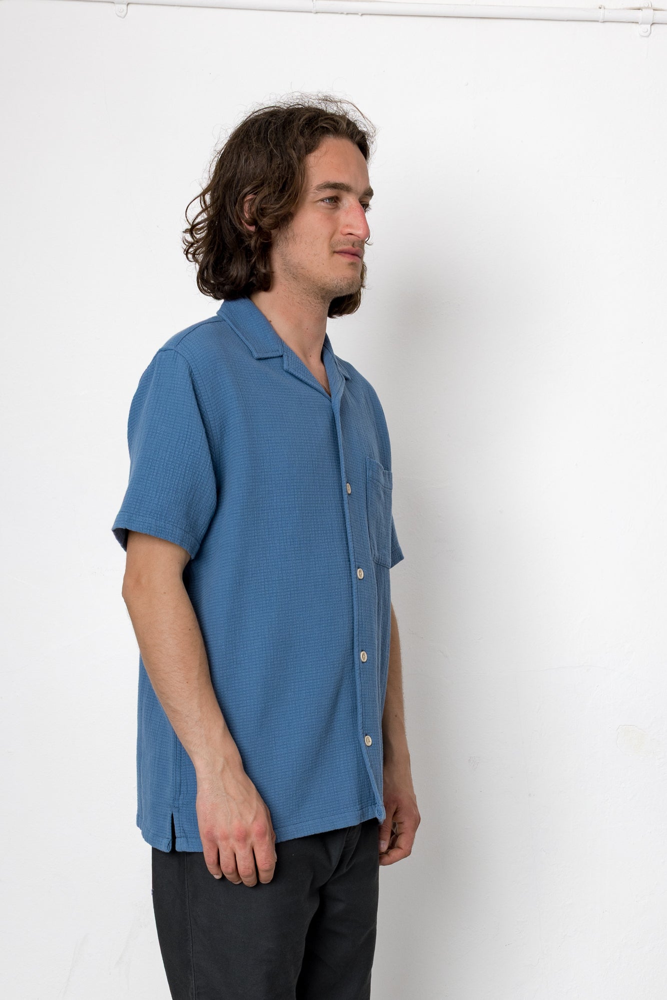 Man wearing a blue shirt against a white background