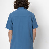 Person wearing a blue shirt from behind on a white background