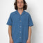 Man wearing a blue short-sleeve shirt against a white background