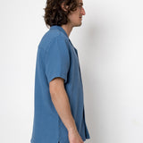 Man wearing a blue shirt against a white background