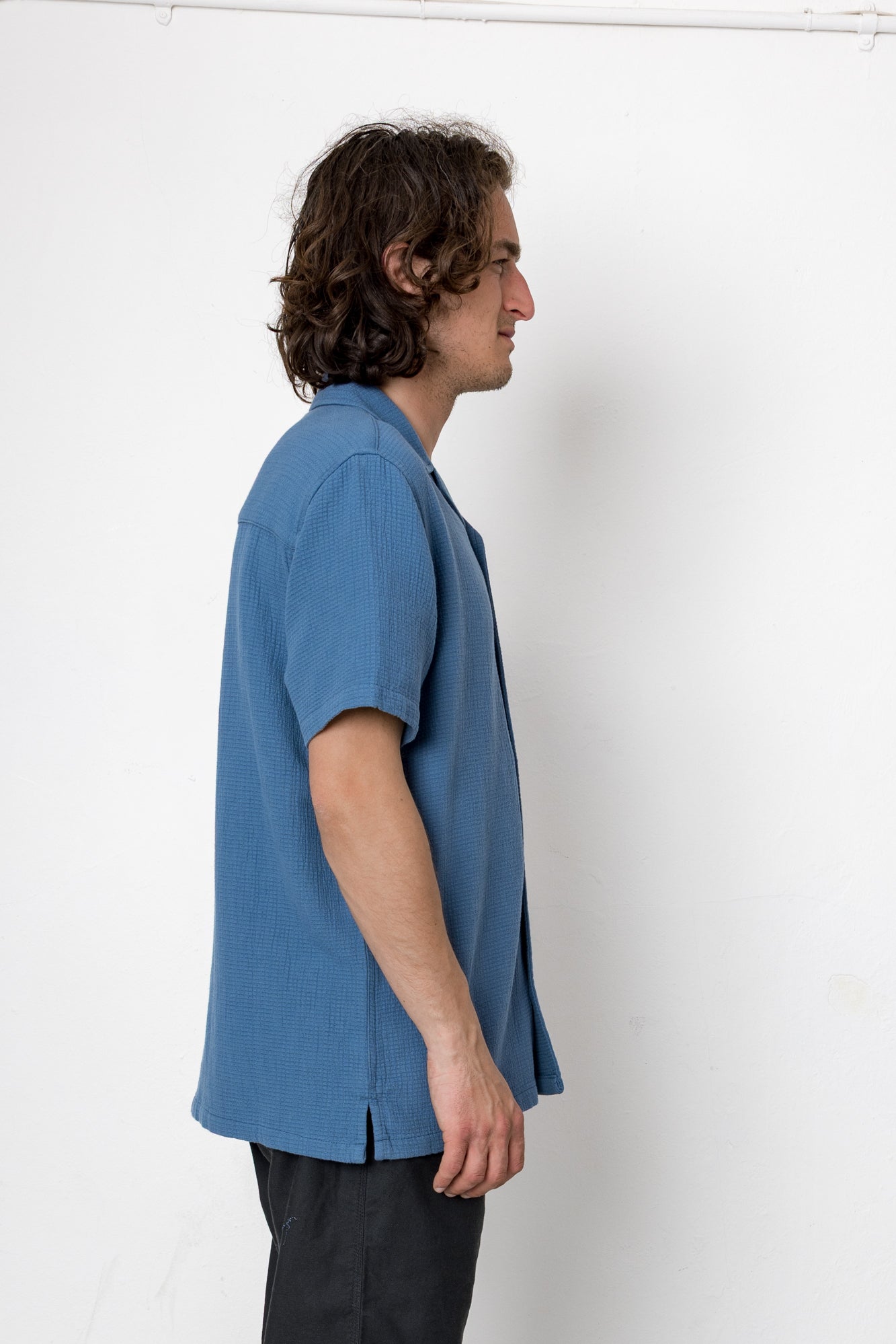 Man wearing a blue shirt against a white background
